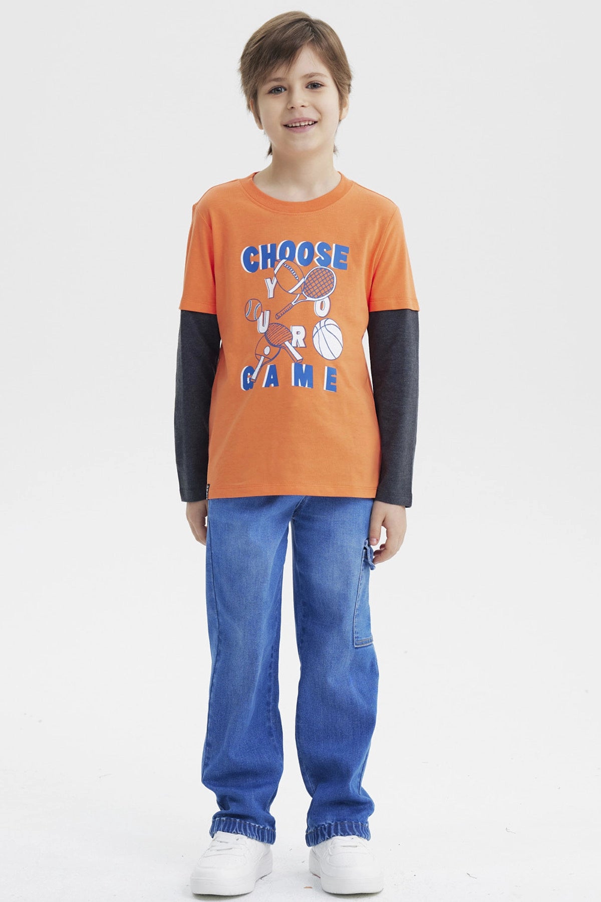 Polera naranja para niño con estampa deportiva al frente que dice Choose Your Game en azul y blanco diseño gráfico grande