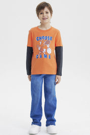 Polera naranja para niño con estampa deportiva al frente que dice Choose Your Game en azul y blanco diseño gráfico grande