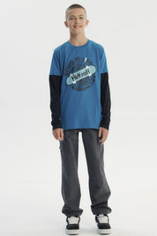 Polera niño color petróleo con estampa central de skate y texto Speed is life Freestyle New York Legends Extreme Life estilo urbano
