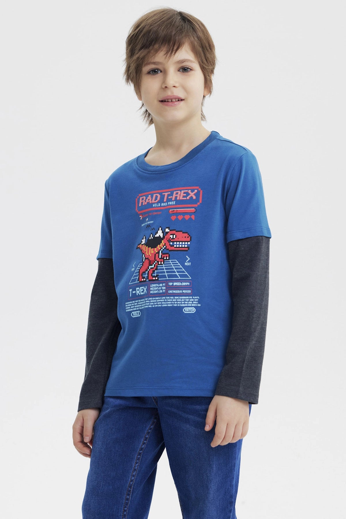 Polera niño petróleo con estampa de dinosaurio pixelado en el centro estilo videojuego retro
