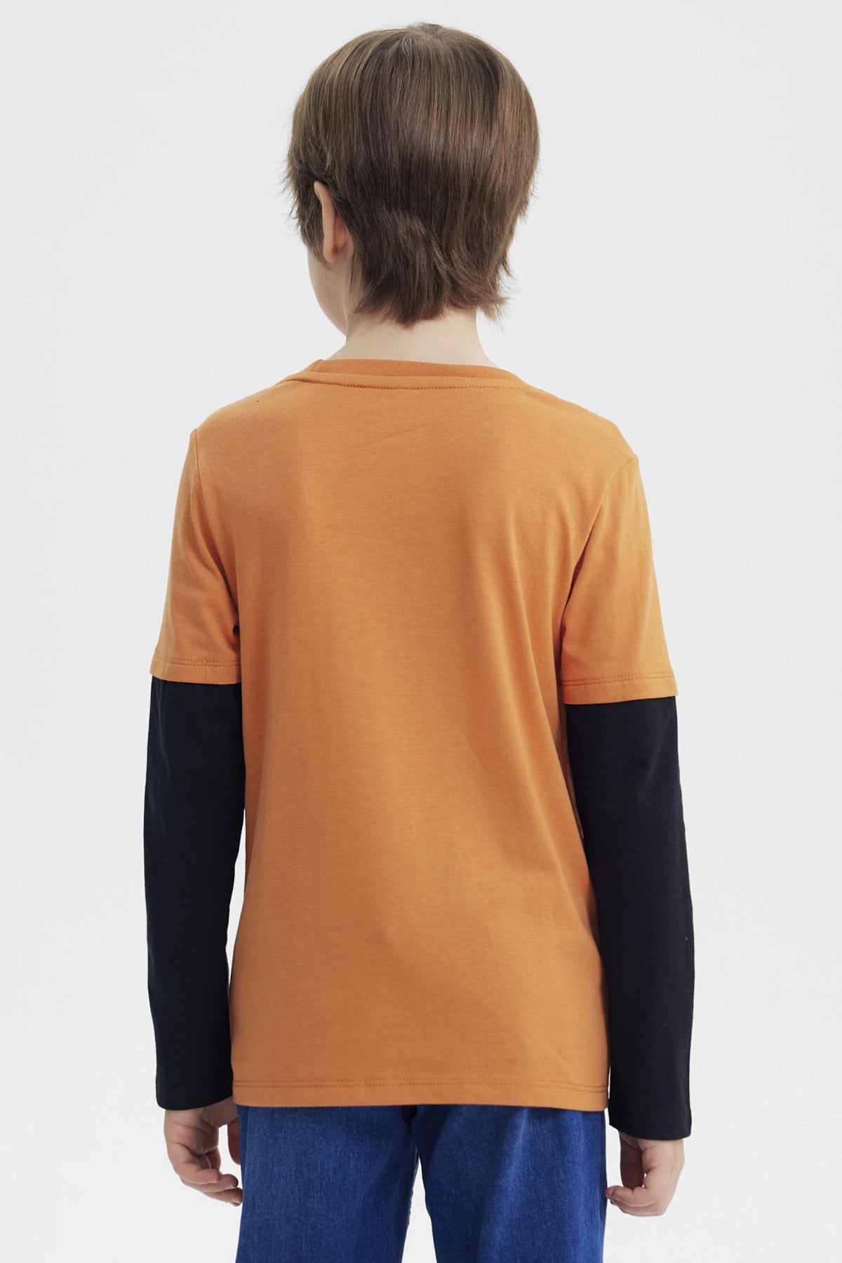 Polera de niño naranjo oscuro con estampa de perro skater en el centro y texto Relax All Day en estilo animado
