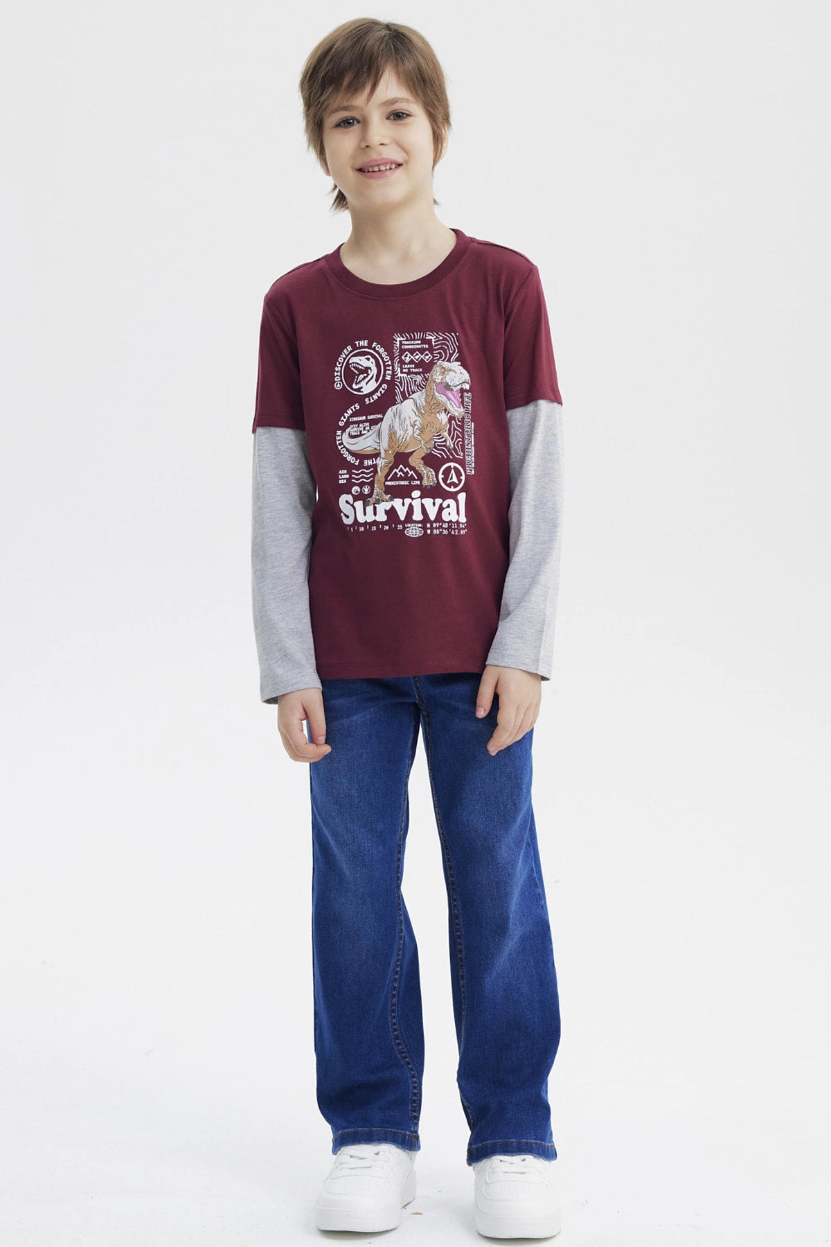 Polera burdeo de niño con estampa grande de dinosaurio en el centro rodeado de texto Survival estilo gráfico moderno