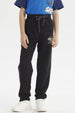 Pantalón buzo negro para niño con diseño de logo en la pierna izquierda estilo casual y cordones ajustables