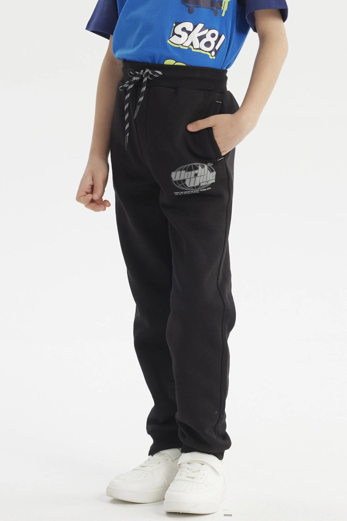 Pantalón buzo negro para niño con diseño de logo en la pierna izquierda estilo casual y cordones ajustables