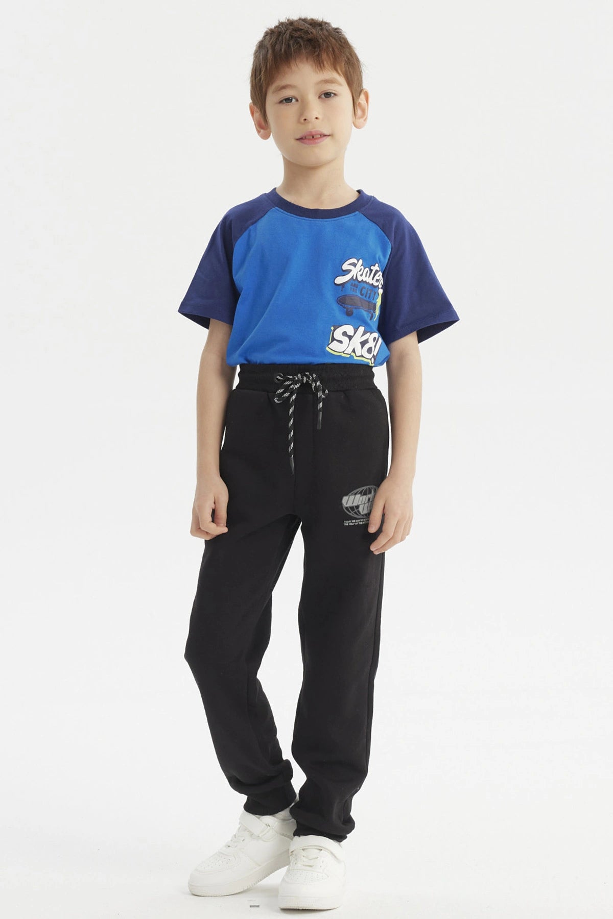 Pantalón buzo negro para niño con diseño de logo en la pierna izquierda estilo casual y cordones ajustables