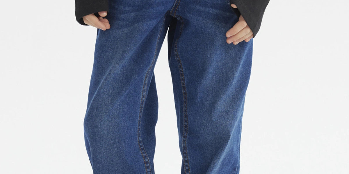 Jeans de niño azul oscuro con diseño liso corte recto y costuras visibles combinados con camiseta de manga larga