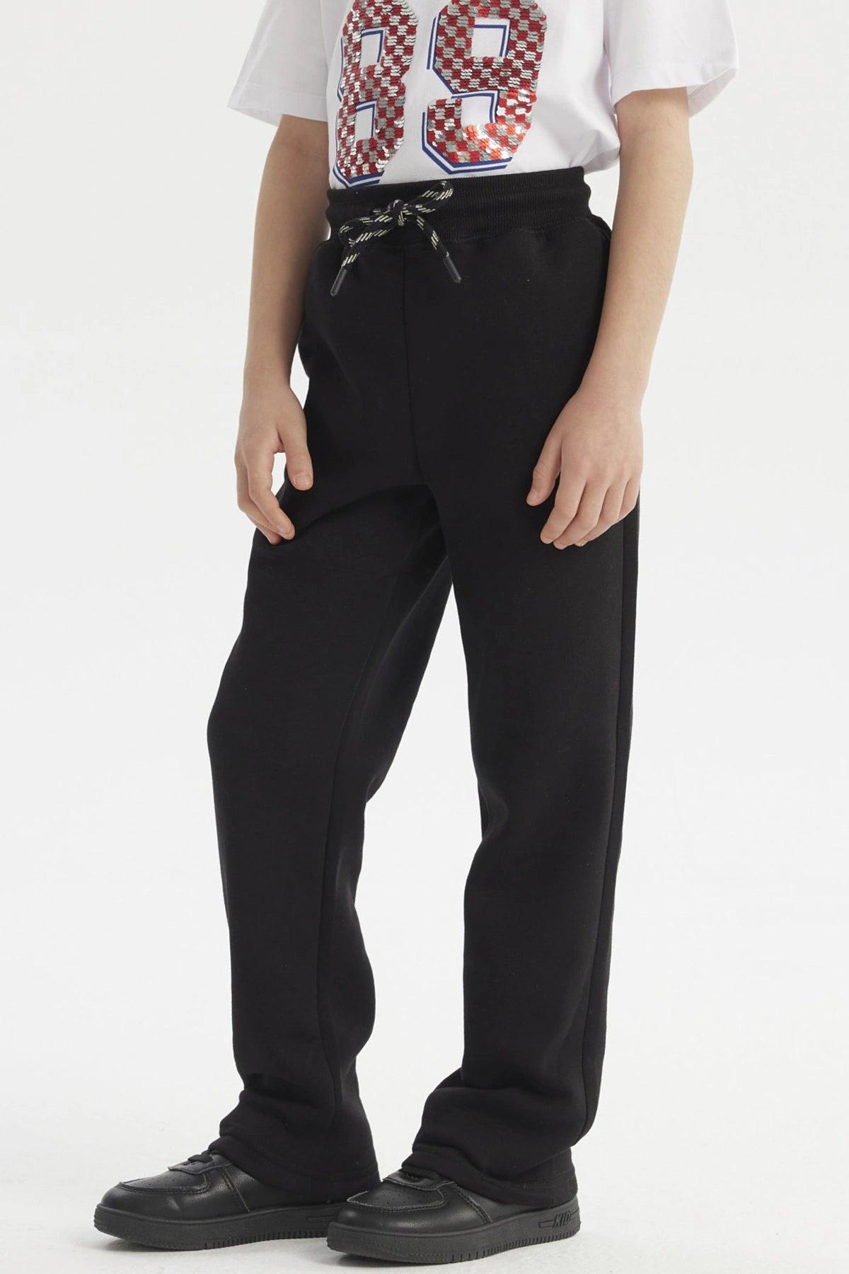 Pantalón buzo niño negro con calce recto y cordón en la cintura prenda lisa ideal para días de juego