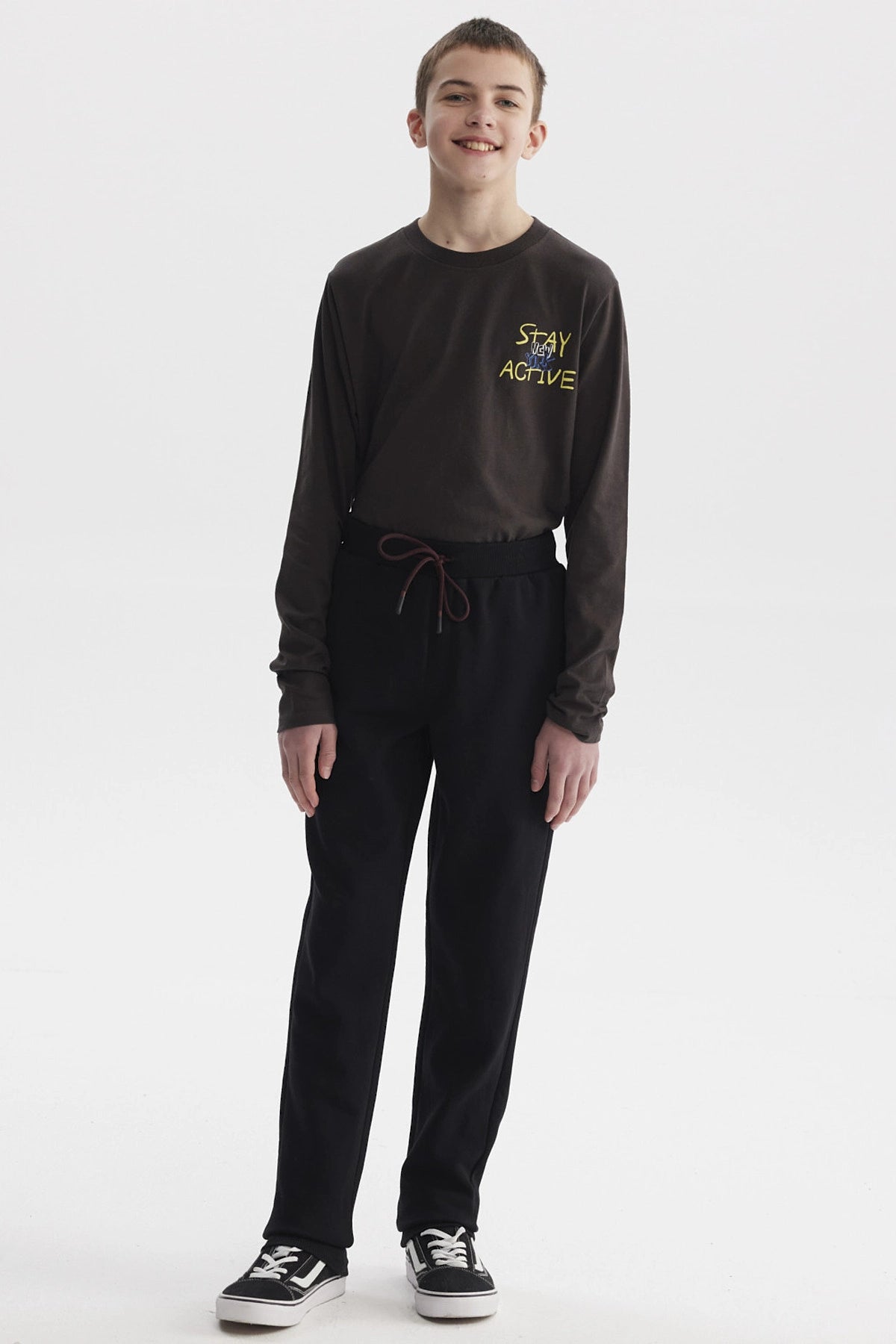 Pantalón buzo gris melange para niño con ajuste de cordón en la cintura y diseño liso ideal para actividades diarias