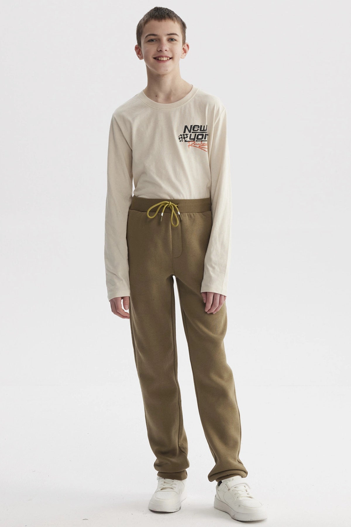 Pantalón buzo niño verde militar con cintura elástica y cordón ajustable diseño liso cómodo para el día a día