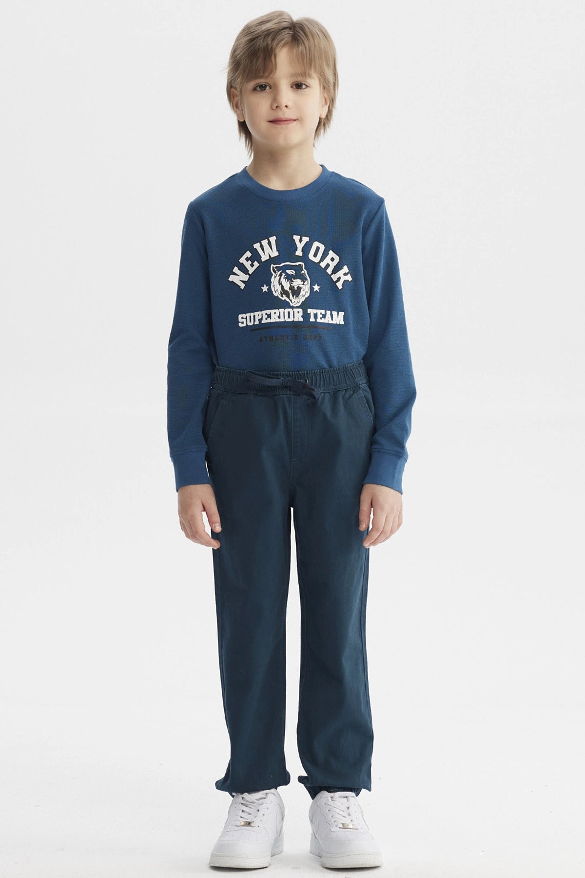 Pantalón niño básico color petróleo con pretina elástica y cordón ajustable diseño liso