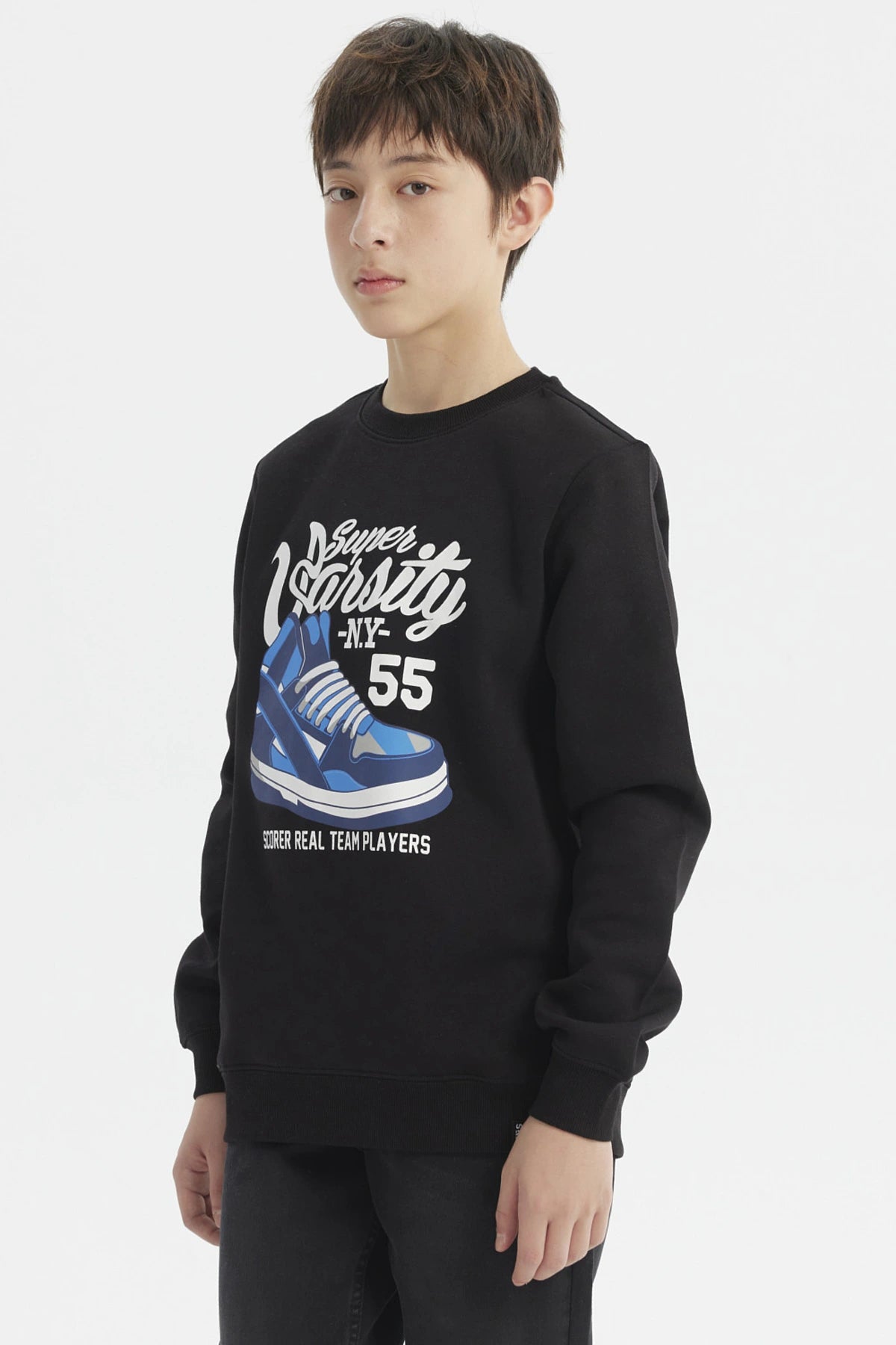Polerón negro de niño con diseño gráfico grande de zapatilla azul en el frente y texto Super Varsity N.Y. 55