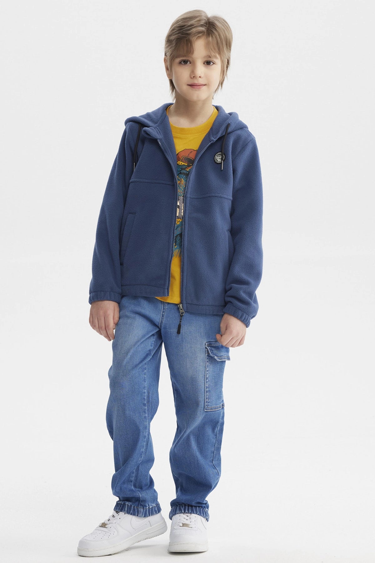 Polar azul para niño con cierre frontal y capucha prenda lisa con detalle de parche en el pecho estilo casual moderno