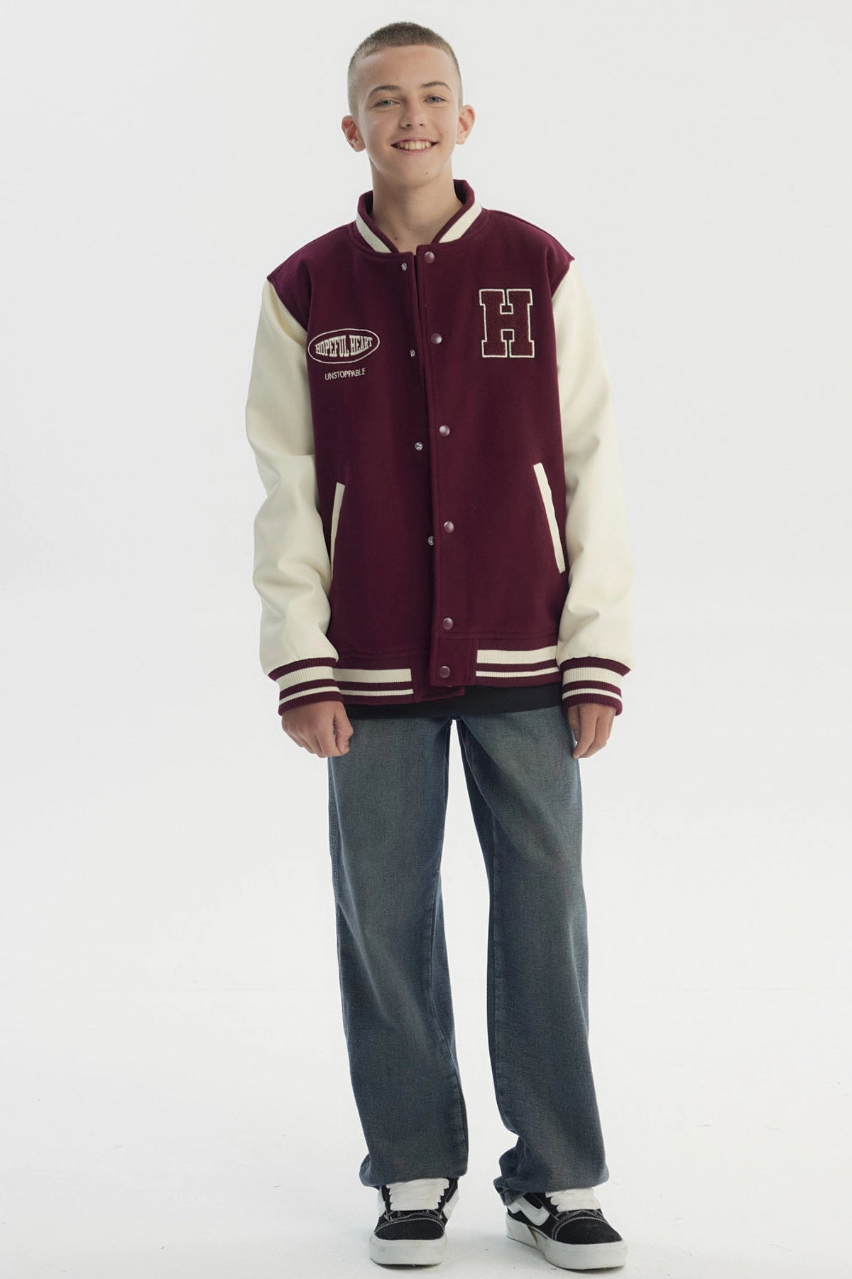 Chaqueta niño burdeo con cuello en V y mangas crema estilo varsity con letra H grande bordada en el pecho