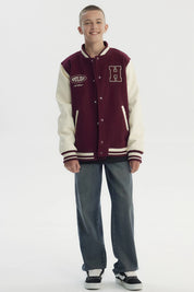 Chaqueta niño burdeo con cuello en V y mangas crema estilo varsity con letra H grande bordada en el pecho