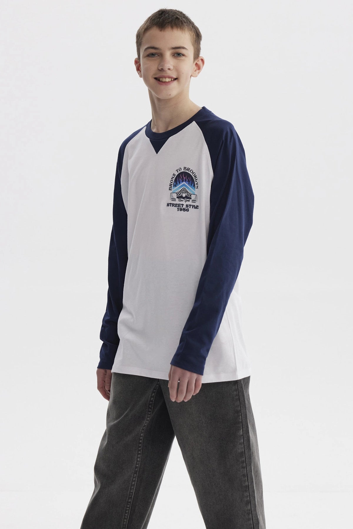 Polera blanca para niño con mangas largas azul marino diseño "Bronx to Brooklyn Street Style 1986" en el pecho