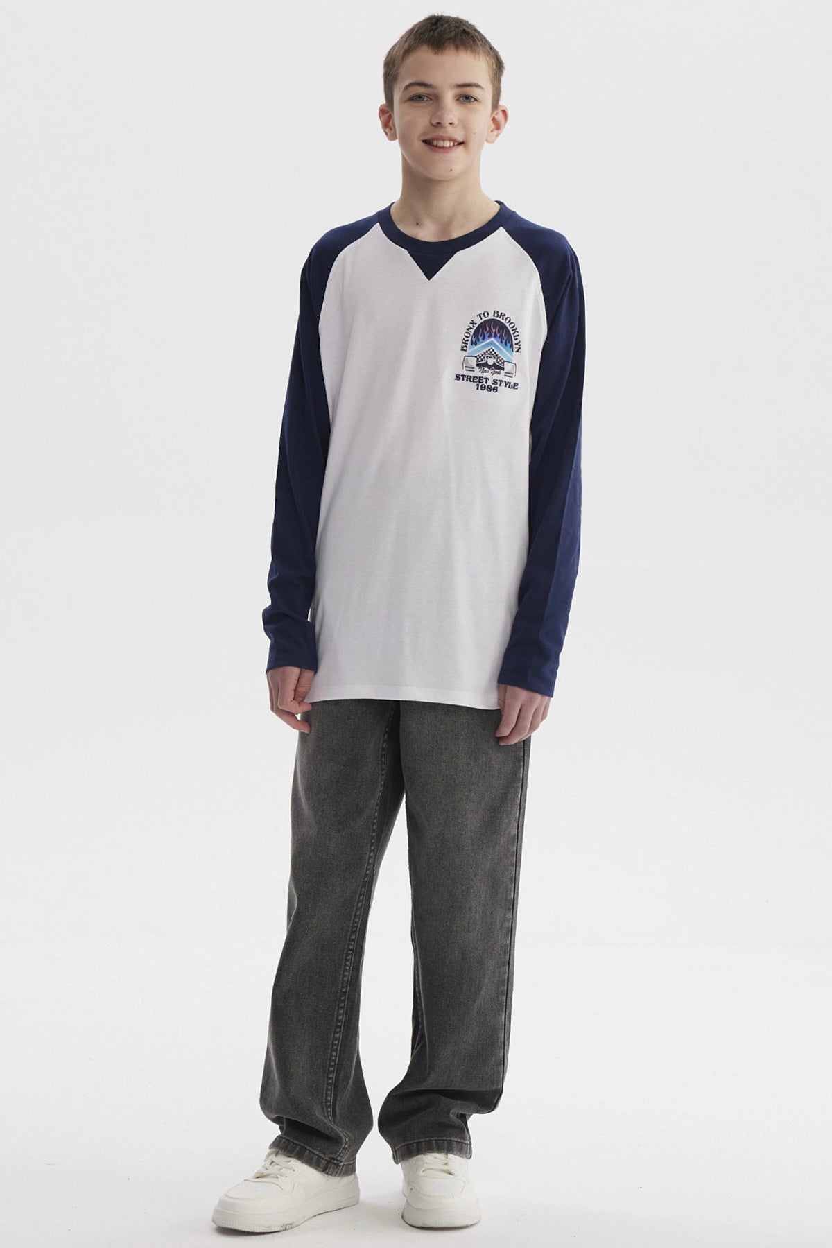 Polera blanca para niño con mangas largas azul marino diseño "Bronx to Brooklyn Street Style 1986" en el pecho