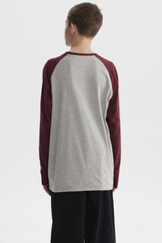 Polera de niño crudo con mangas largas burdeos y estampa pequeña de control de videojuegos en el pecho con texto Game Over