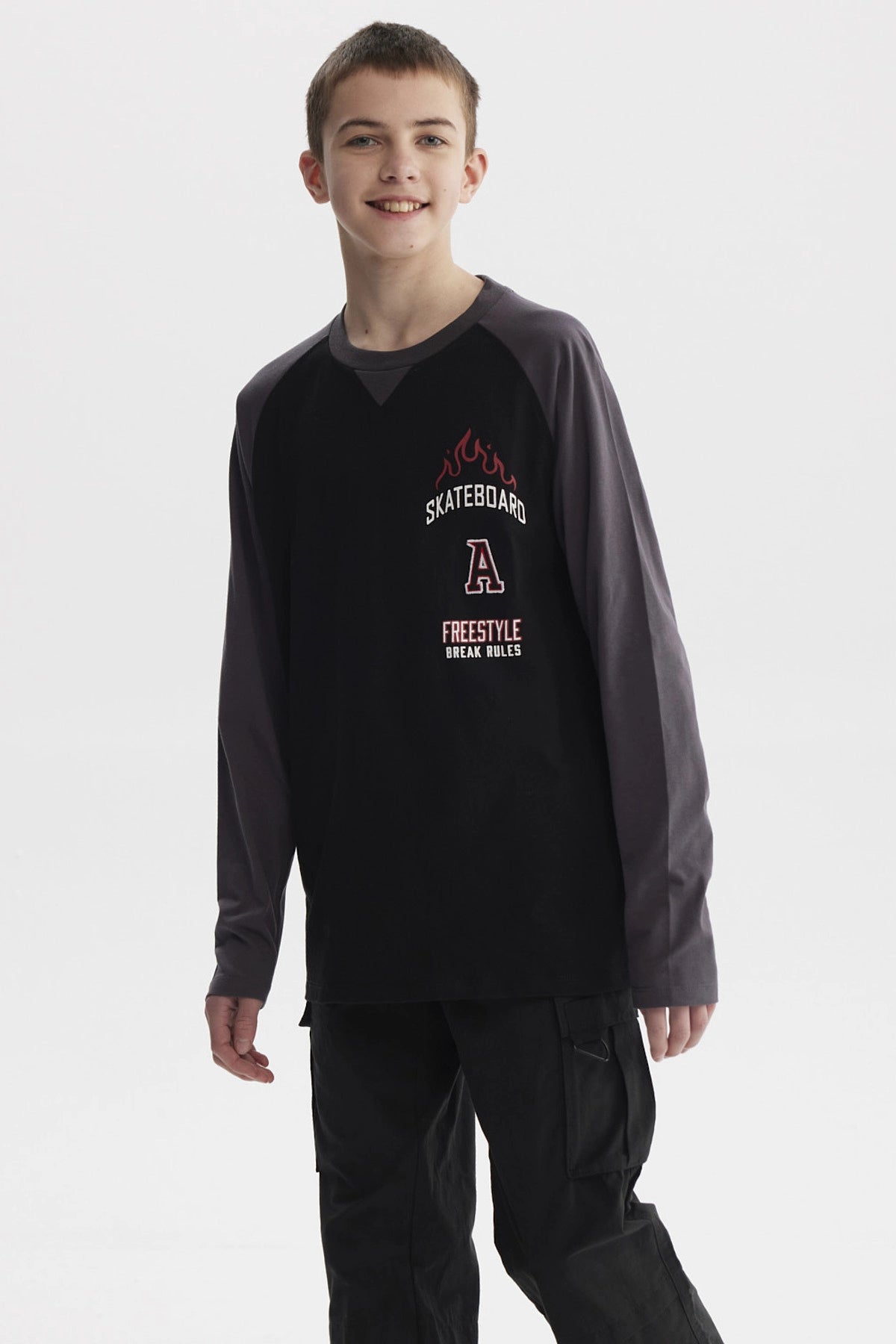 Polera negra para niño con mangas largas gris oscuro y estampado de skate con llamas y texto en el pecho