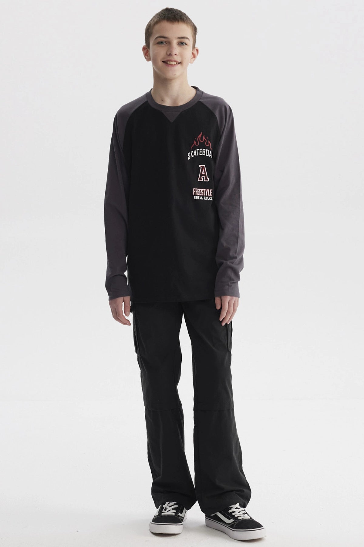 Polera negra para niño con mangas largas gris oscuro y estampado de skate con llamas y texto en el pecho