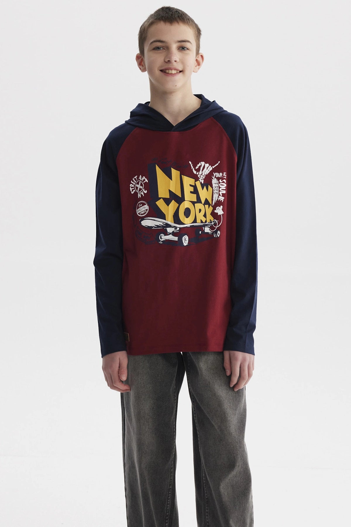 Polera niño bicolor burdeo con mangas largas azul marino y estampa grande de New York en el centro estilo urbano