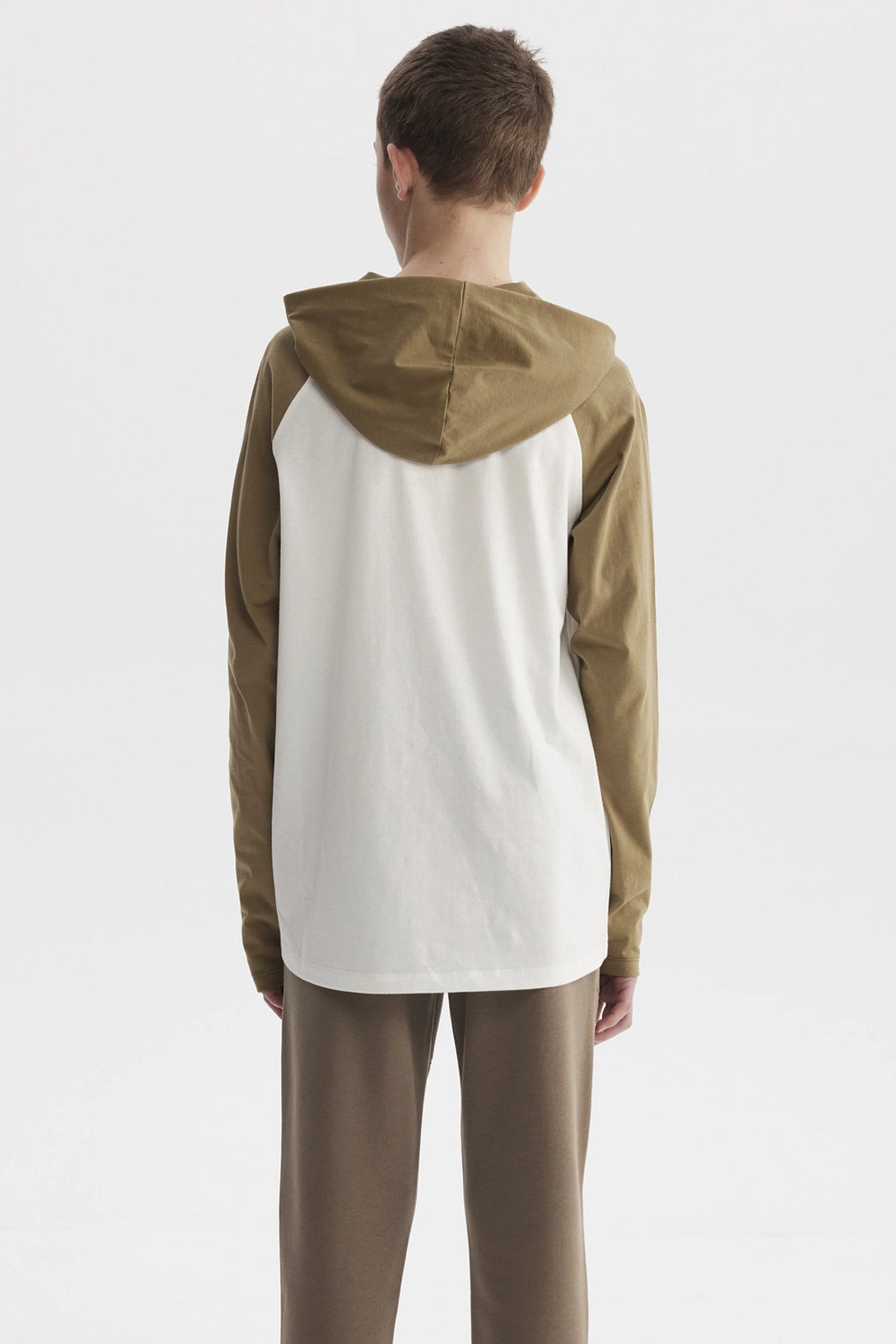 Polera de niño crudo con mangas largas color oliva y estampado central grande de letras y números estilo universitario