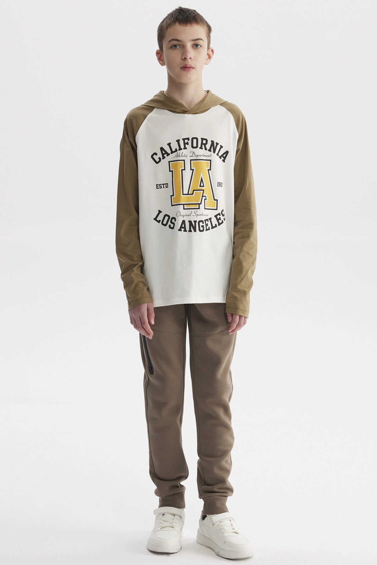 Polera de niño crudo con mangas largas color oliva y estampado central grande de letras y números estilo universitario
