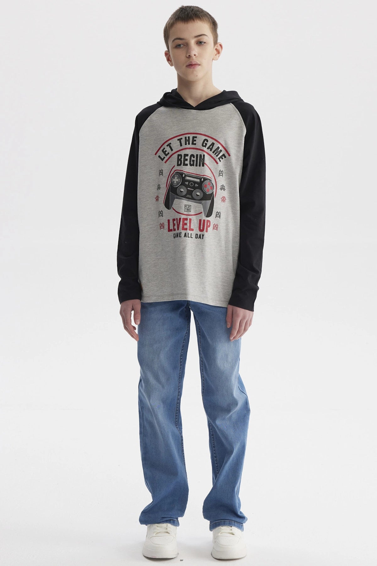 Polera niño teen gris melange con mangas negras y estampa de control de videojuego en el frente estilo casual