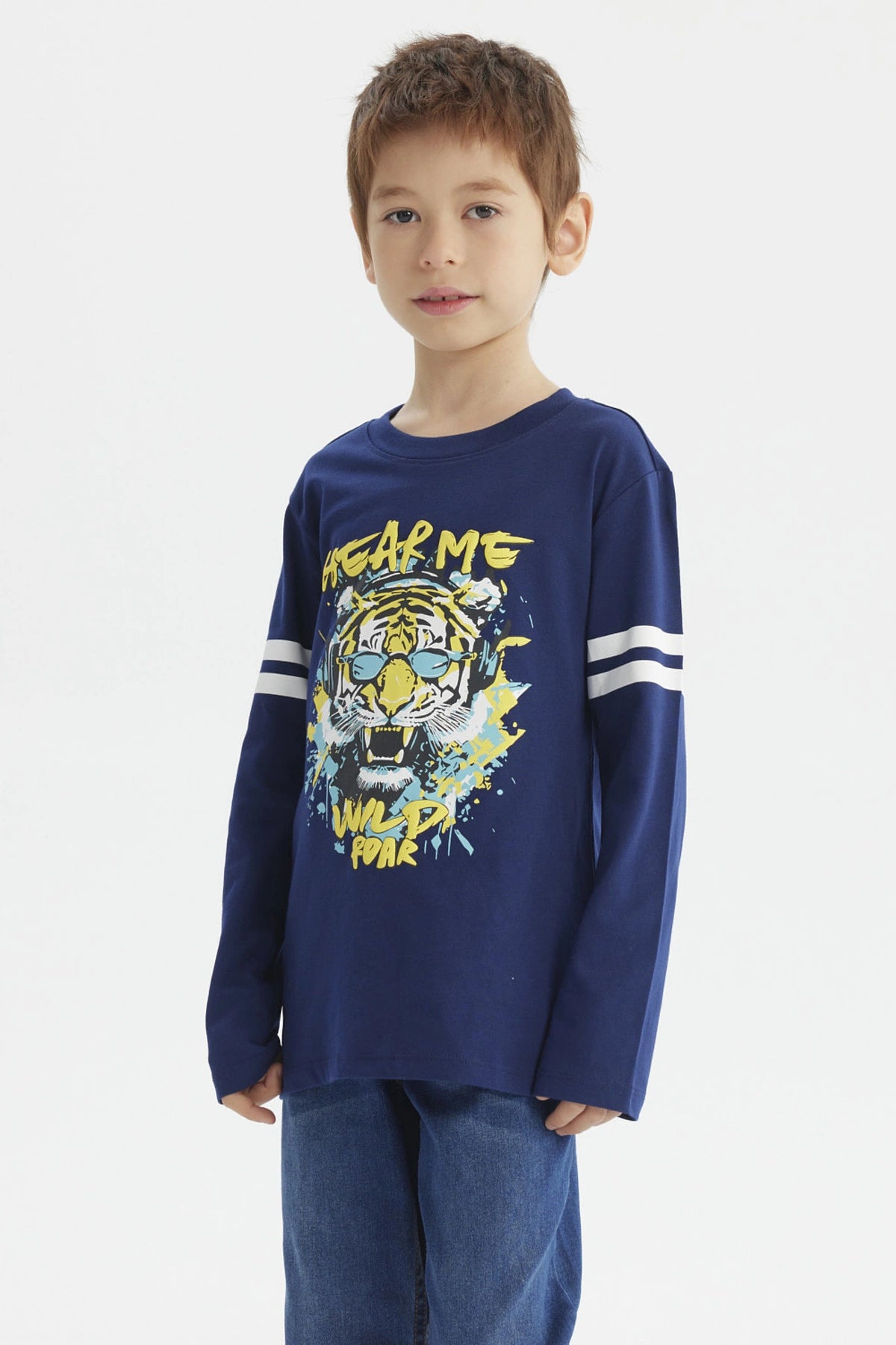 Polera azul oscuro para niño con franjas blancas en mangas y estampa central de tigre con gafas audífonos y texto Hear Me Wild Roar