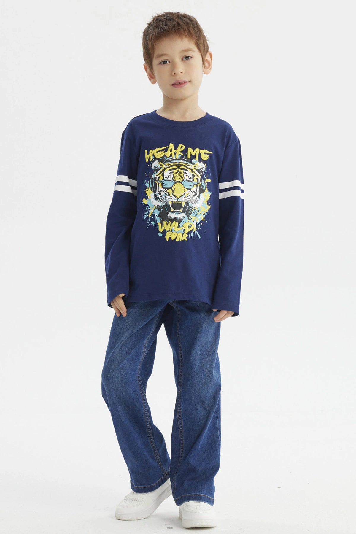 Polera azul oscuro para niño con franjas blancas en mangas y estampa central de tigre con gafas audífonos y texto Hear Me Wild Roar