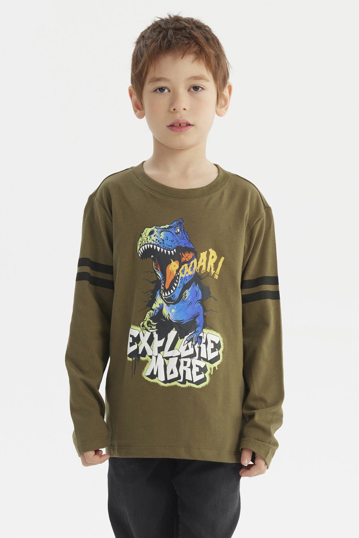 Polera de niño verde militar con dinosaurio azul y texto Roaar Explore More al frente estilo gráfico divertido