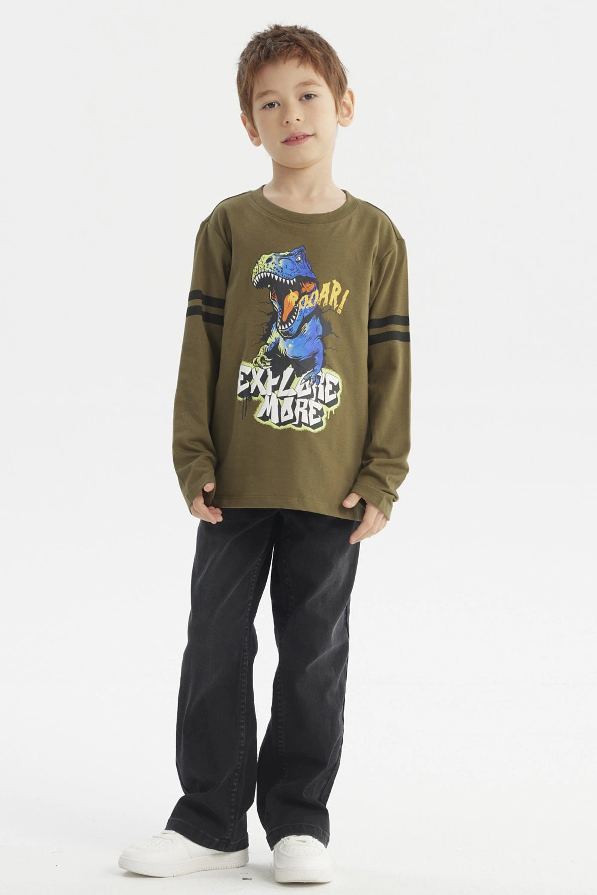 Polera de niño verde militar con dinosaurio azul y texto Roaar Explore More al frente estilo gráfico divertido