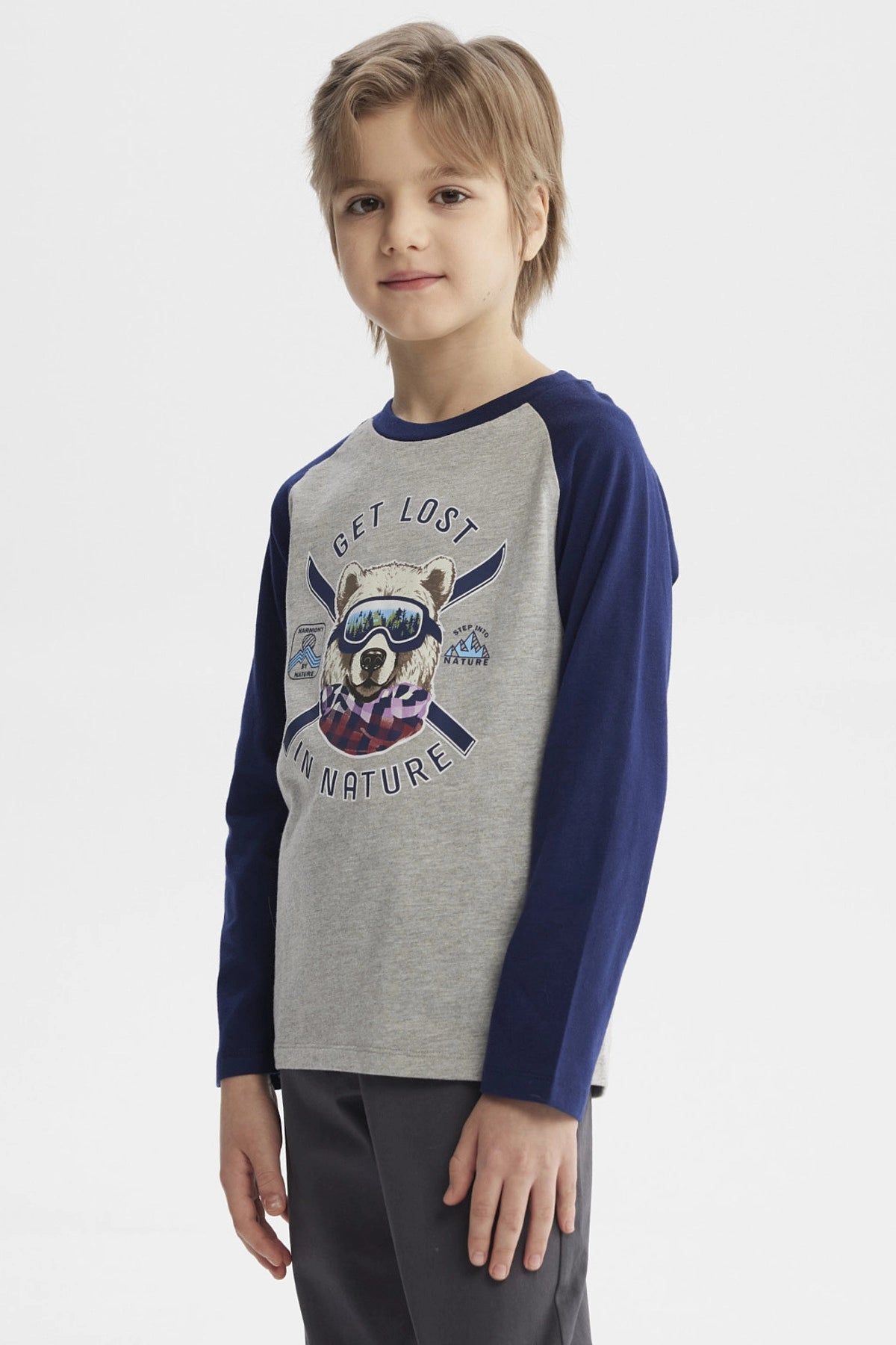 Polera gris melange de niño con mangas azul oscuro y estampa de oso con gafas y bufanda en el centro