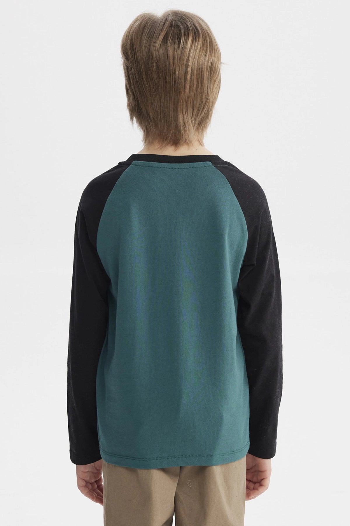 Polera verde oscuro con mangas negras y estampado central de lobo aullando frente a luna llena con texto Travel and Adventure