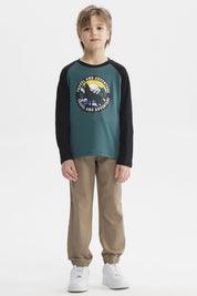 Polera verde oscuro con mangas negras y estampado central de lobo aullando frente a luna llena con texto Travel and Adventure