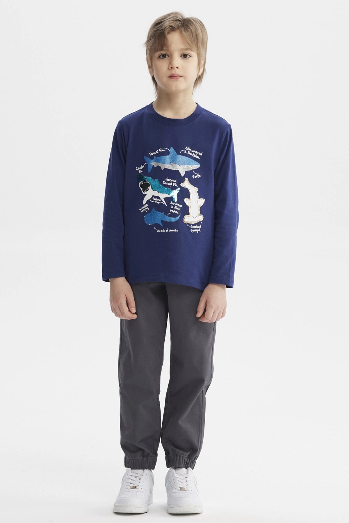 Polera azul oscuro para niño con estampado de tiburones y texto explicativo en el frente estilo gráfico