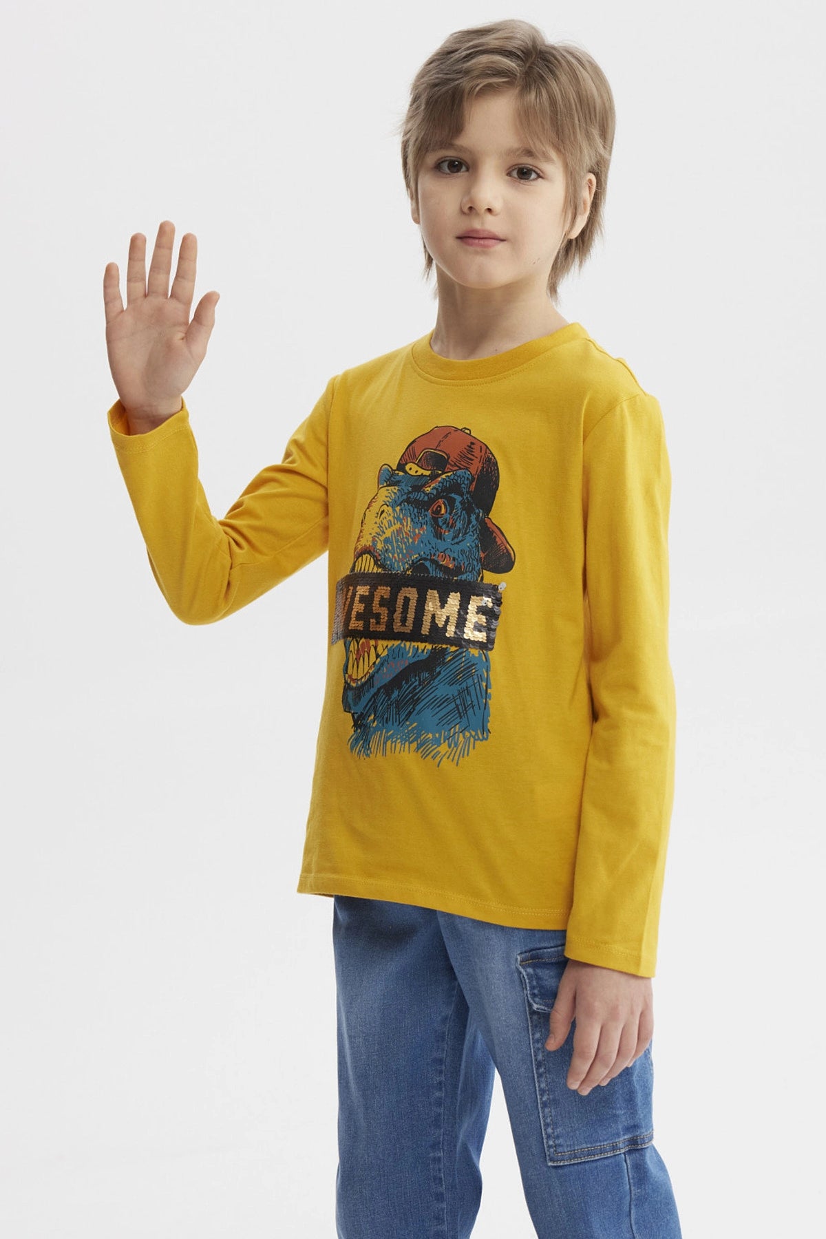 Polera mostaza para niño con estampa de dinosaurio azul y texto AWESOME en el pecho estilo gráfico divertido