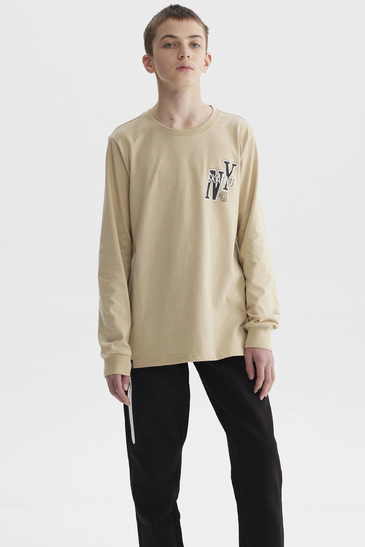 Polera beige de niño con diseño de letras NY en el pecho estilo urbano manga larga con puños elásticos
