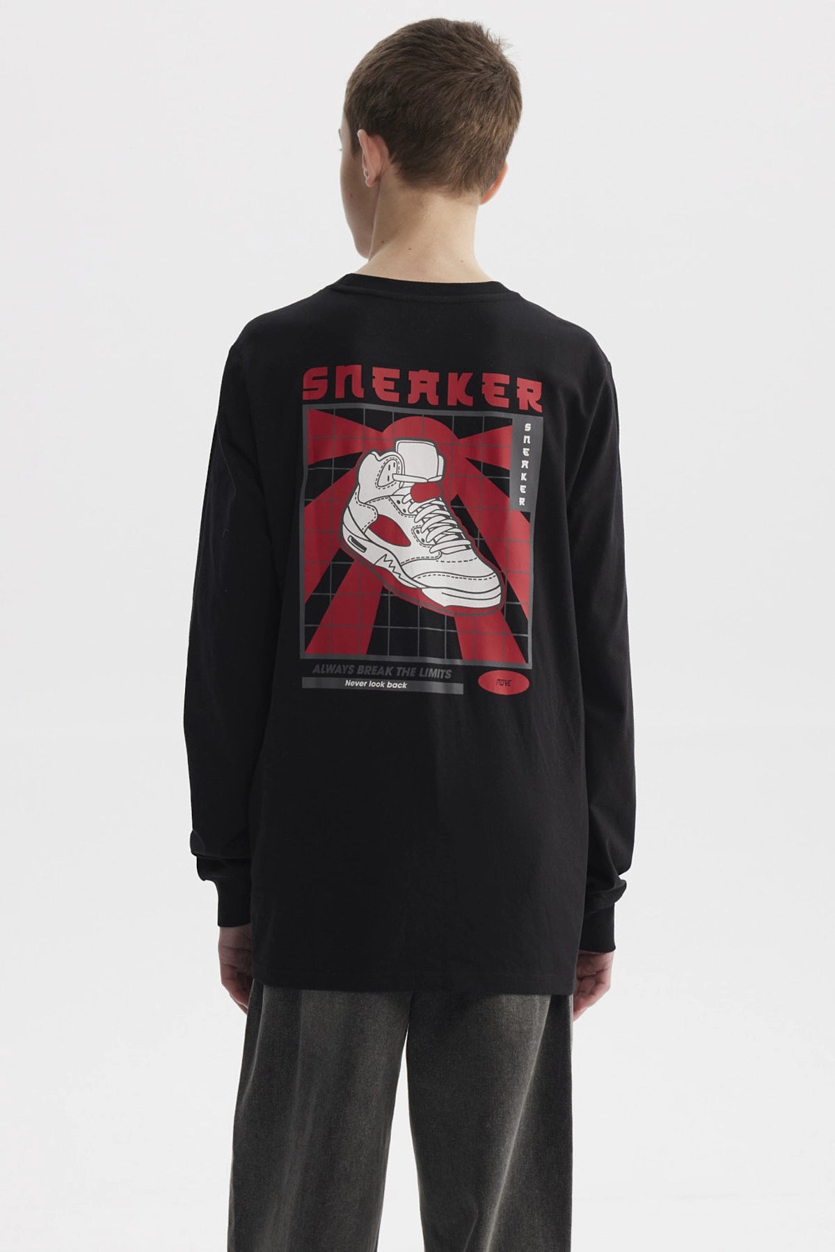 Polera negra para niño con diseño de zapatilla roja y blanca estilo gráfico pequeño en el pecho con texto Sneaker