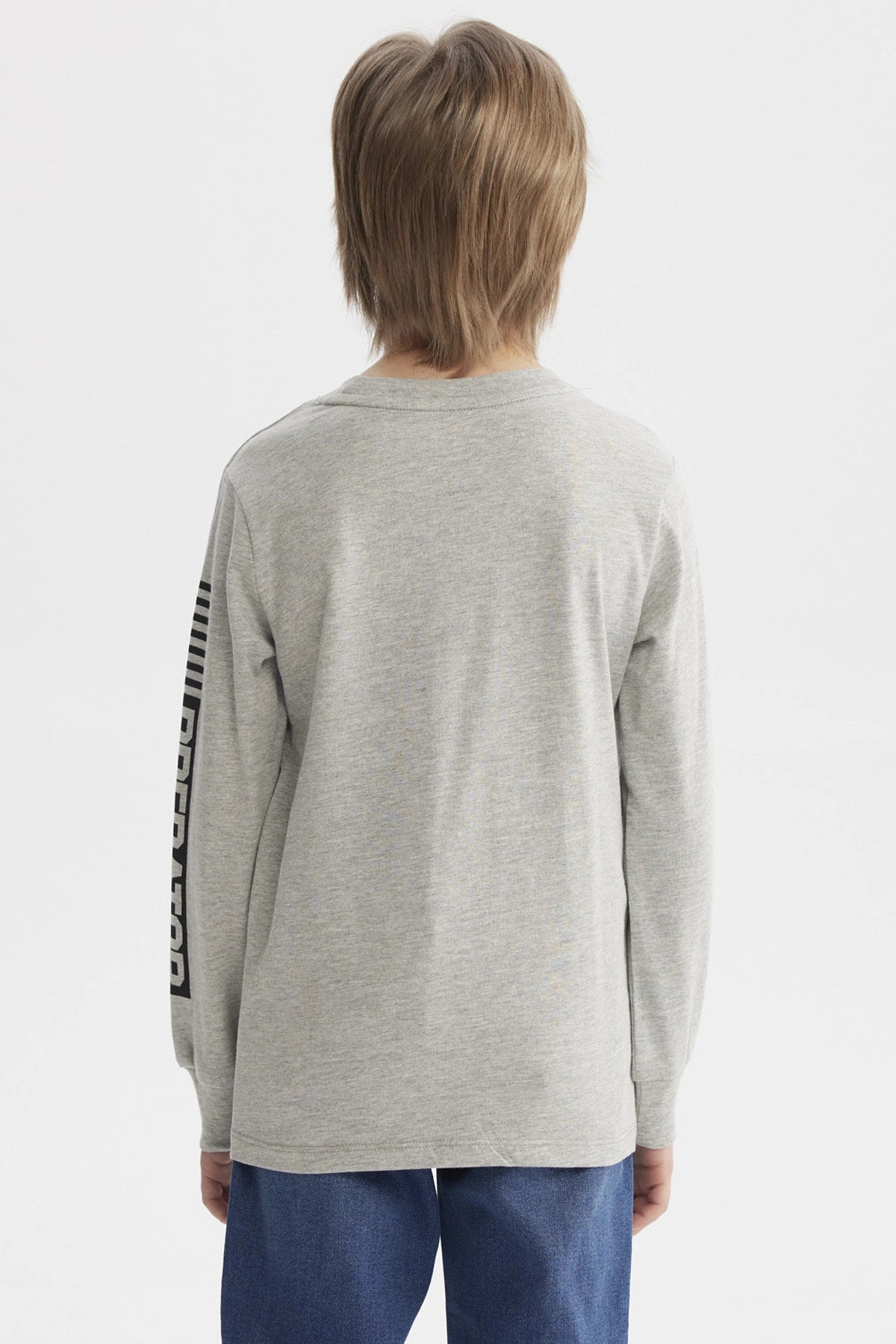Polera niño gris melange con estampado de dinosaurio geométrico grande al frente letras TYRANOSAURUS en naranja