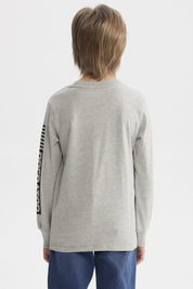 Polera niño gris melange con estampado de dinosaurio geométrico grande al frente letras TYRANOSAURUS en naranja