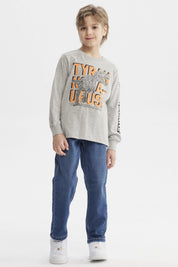 Polera niño gris melange con estampado de dinosaurio geométrico grande al frente letras TYRANOSAURUS en naranja