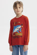 Polera de niño ocre con estampa grande de tiburón azul en estilo gráfico en el centro y texto King of the Deep Sea