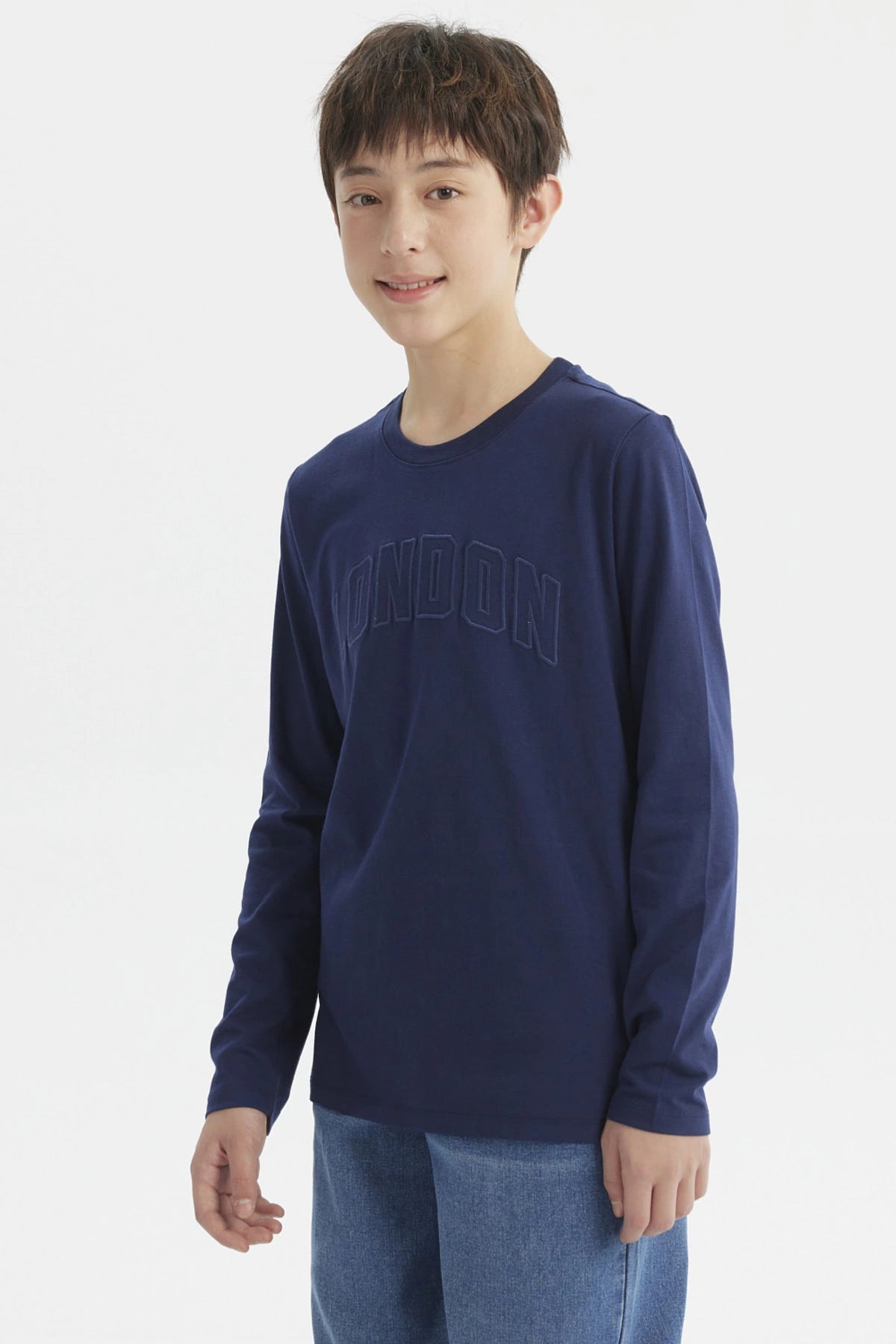 Polera de niño azul oscuro con texto LONDON en relieve en el pecho diseño casual y moderno sin estampa adicional