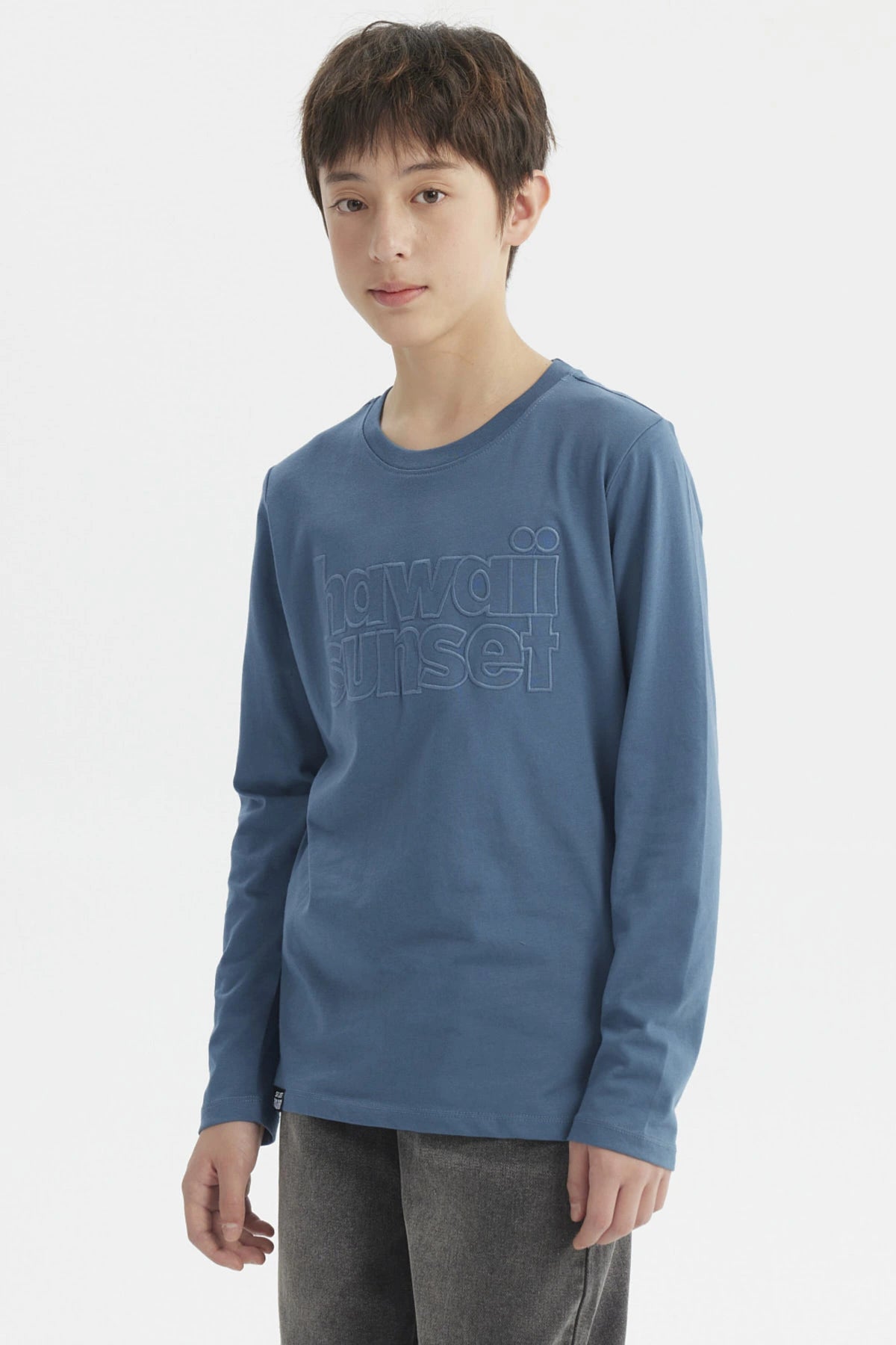 Polera azul petróleo para niño con texto Hawaii Sunset en relieve al frente de estilo casual y manga larga lisa