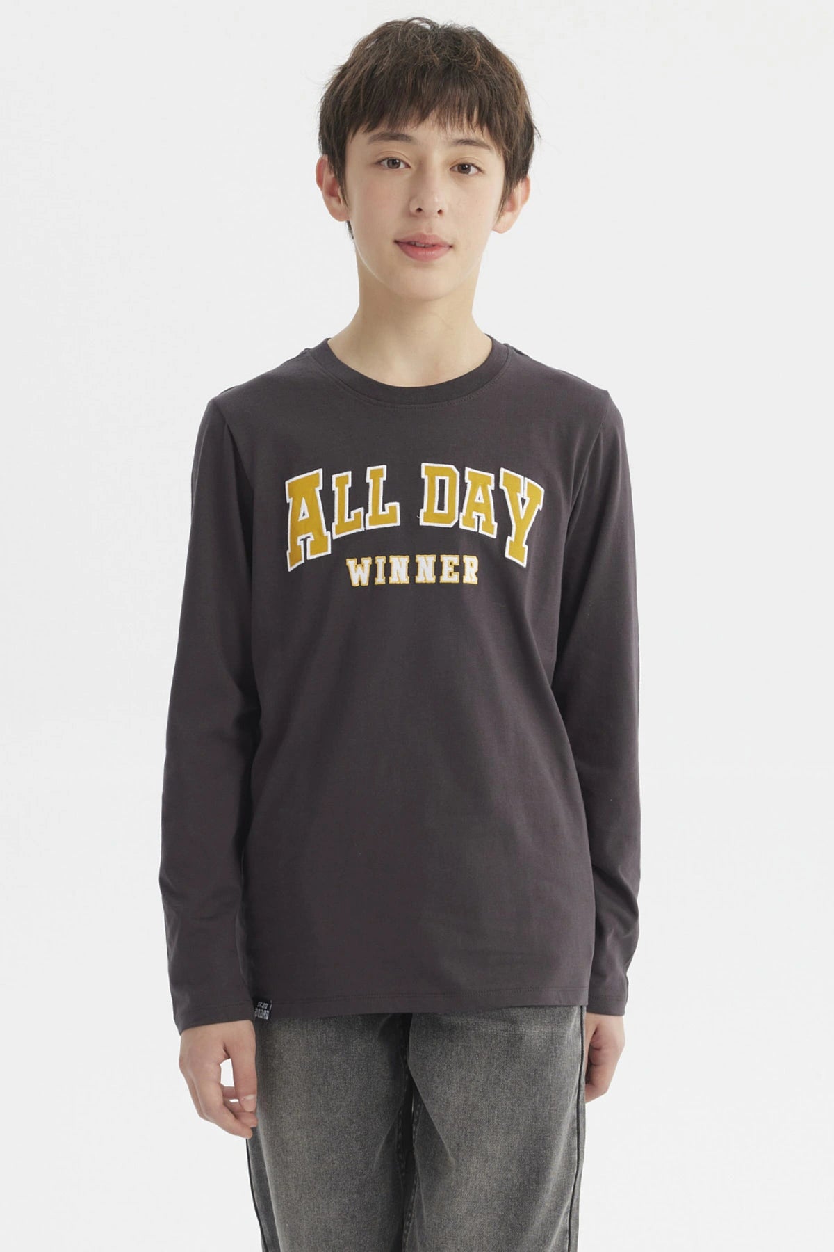 Polera niño marengo con texto ALL DAY WINNER en relieve amarillo al frente estilo casual sin estampa adicional