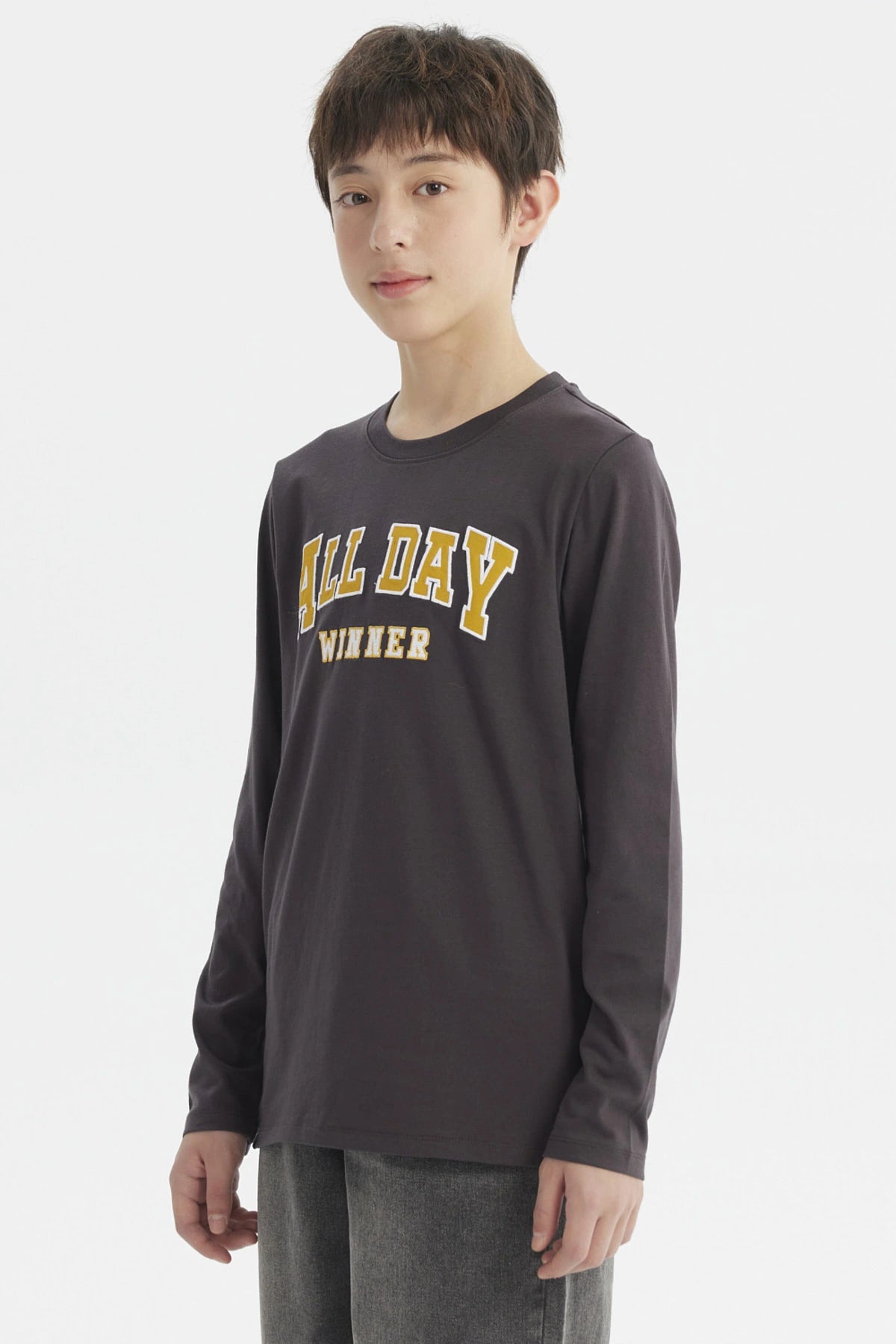 Polera niño marengo con texto ALL DAY WINNER en relieve amarillo al frente estilo casual sin estampa adicional