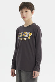 Polera niño marengo con texto ALL DAY WINNER en relieve amarillo al frente estilo casual sin estampa adicional