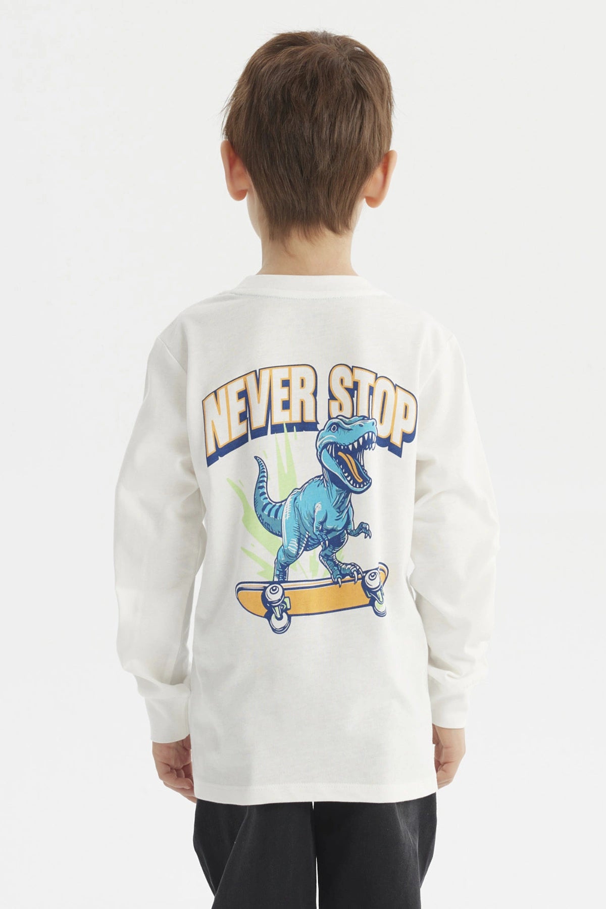 Polera crudo de niño con estampa de dinosaurio azul y texto Just Ride en el pecho estilo casual y gráfico