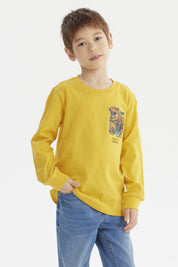 Polera niño mostaza con estampa de dinosaurio grande en el pecho estilo gráfico aventura en la jungla