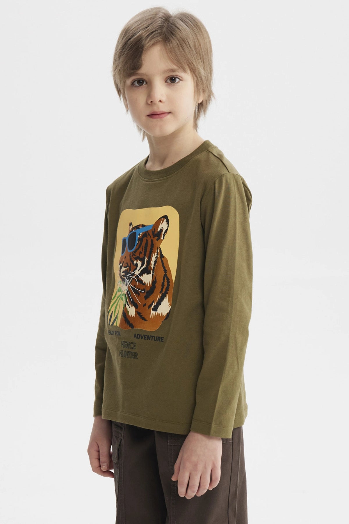 Polera de niño verde militar con estampado de tigre con gafas azules y texto Ready for Adventure Fierce Hunter en el pecho